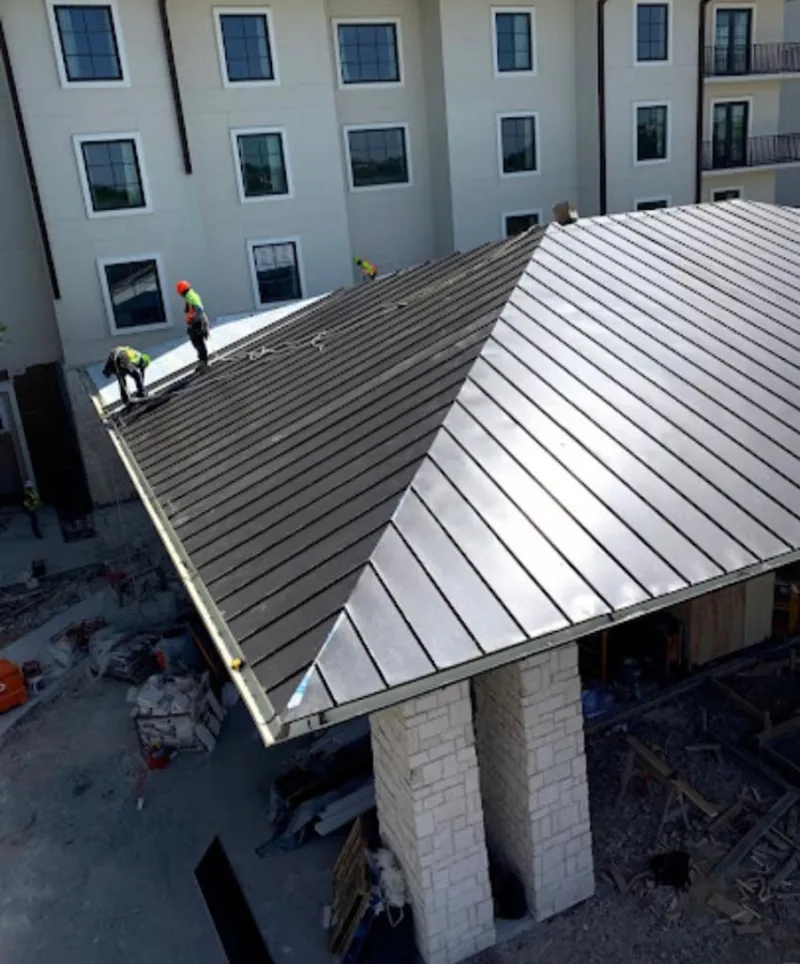 Crew installing standing seam metal roof panels on a commercial project in Bridgewater